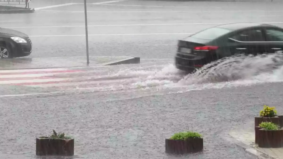 Dos cotxes aixecant aigua del terra en passar per tolls mentre circulen.